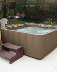 Brown hot tub with steps in a garden setting