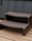 Brown step stool on a wooden deck next to a hot tub.